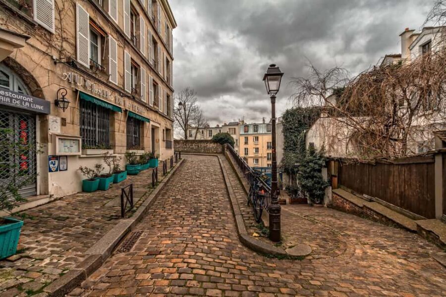 Montmartre Walking Tour in English - Getting your bearings: Metro Blanche, the yellow umbrella, and steep streets